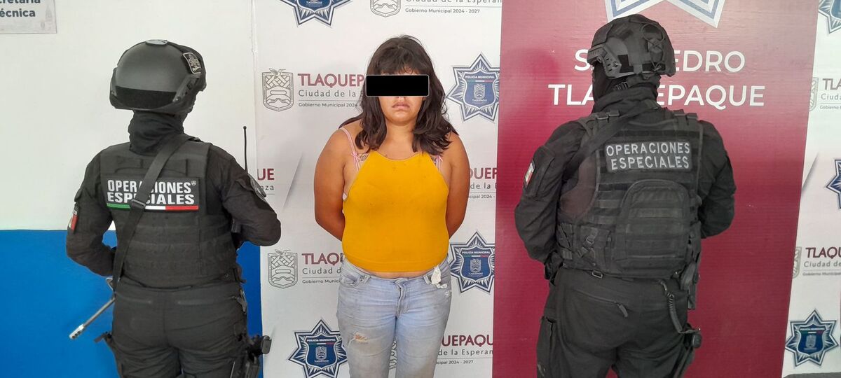 Mujer detenida con dos elementos de autoridad a los lados