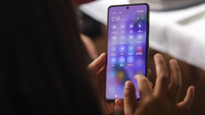 Mujer sosteniendo un teléfono celular con sus manos.