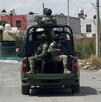 Se observa unos militares arriba de una camioneta que circula por enmedio de una colonia.