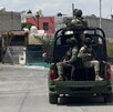 Se observa unos militares arriba de una camioneta que circula por enmedio de una colonia.