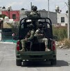 Se observa unos militares arriba de una camioneta que circula por enmedio de una colonia.