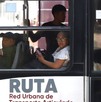 Personas viajando en un metrobús en Puebla vistas desde afuera.