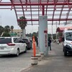 Se observa una ambulancia estacionada afuera de un edificio y un vehículo enfrente.