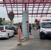 Se observa una ambulancia estacionada afuera de un edificio y un vehículo enfrente.