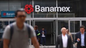 Personas caminando junto a una sucursal del banco Banamex en México.