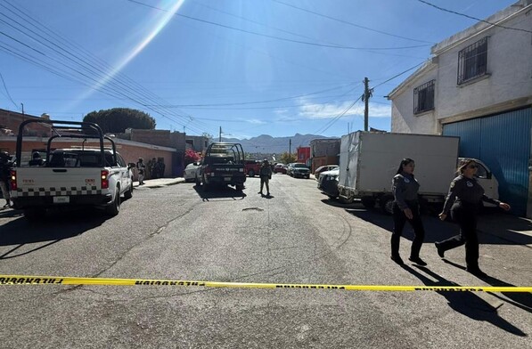 Se observa a varias mujeres con uniforme de policía caminando en la vialidad, hay una cintilla amarilla de precaución.
