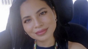 Mujer sonríe desde el asiento de un vehículo.