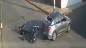 Conductor de motocicleta siendo atropellado por un automóvil.
