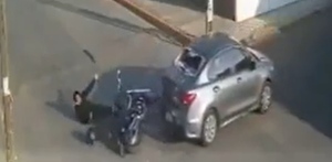 Conductor de motocicleta siendo atropellado por un automóvil.