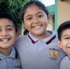 Niños de primaria sonriendo por registro a beca Rita Cetina