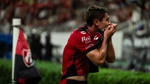 Jugador de Atlas celebrando un gol besando el escudo del equipo.