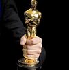 Premio Oscar en la mano de una persona.