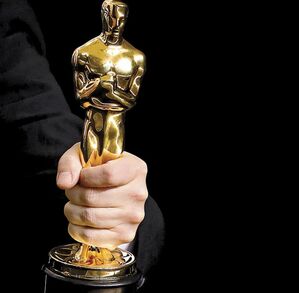 Premio Oscar en la mano de una persona.