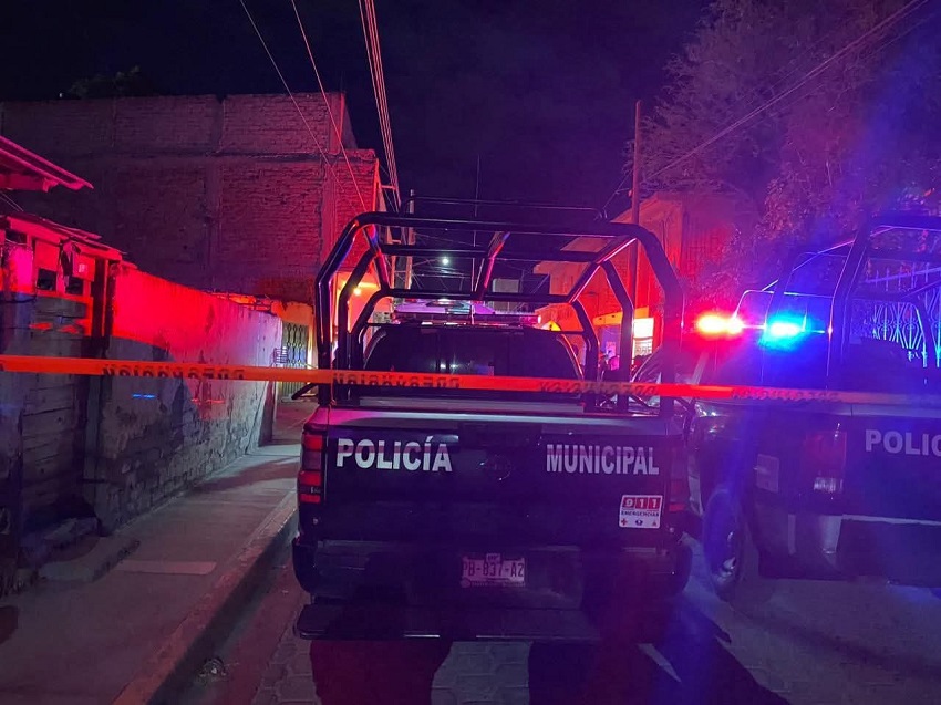 Patrulla de policía junto a una cinta roja.