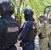 Dos oficiales de la Policía Estatal de Colima junto s dos militares de la marina al lado de una patrulla del estado