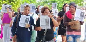 Mujeres caminan con la imagen de una niña desaparecida en Veracruz.