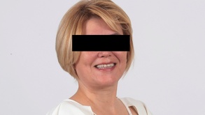 Foto de una mujer con cabello corto y rubio con una cinta negra sobre los ojos.