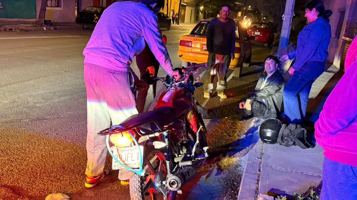 Se observa a un hombre sentado en el piso, hay una patrulla que está agarrando una moto.