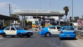 Taxis en color azul tapando el paso en una caseta del municipio de Tehuacán.