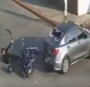 Conductor de motocicleta siendo atropellado por un automóvil.