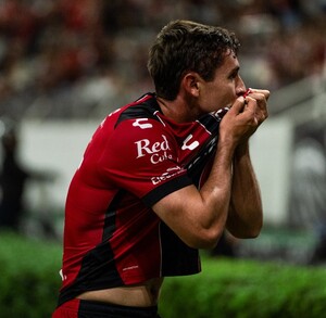Jugador de Atlas celebrando un gol besando el escudo del equipo.