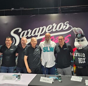 Se observa a varios hombres parados, tienen una mesa enfrente.