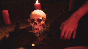 Cráneo humano con velas alrededor.