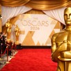 Imagen generada con IA (Sora) de la alfombra roja de los Premios Oscar 2026. Se pueden ver fotógrafos y en primer plano se observa la estatuilla de los premios