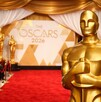 Imagen generada con IA (Sora) de la alfombra roja de los Premios Oscar 2026. Se pueden ver fotógrafos y en primer plano se observa la estatuilla de los premios