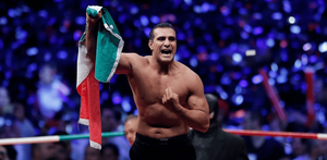 Alberto del Río festeja con la bandera mexicana tras su aparición en un evento de lucha libre.