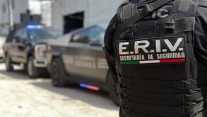 Oficial de la Secretaría de Seguridad Jalisco visto de espaldas con patrullas Cybertruck vistas en el fondo desenfocadas