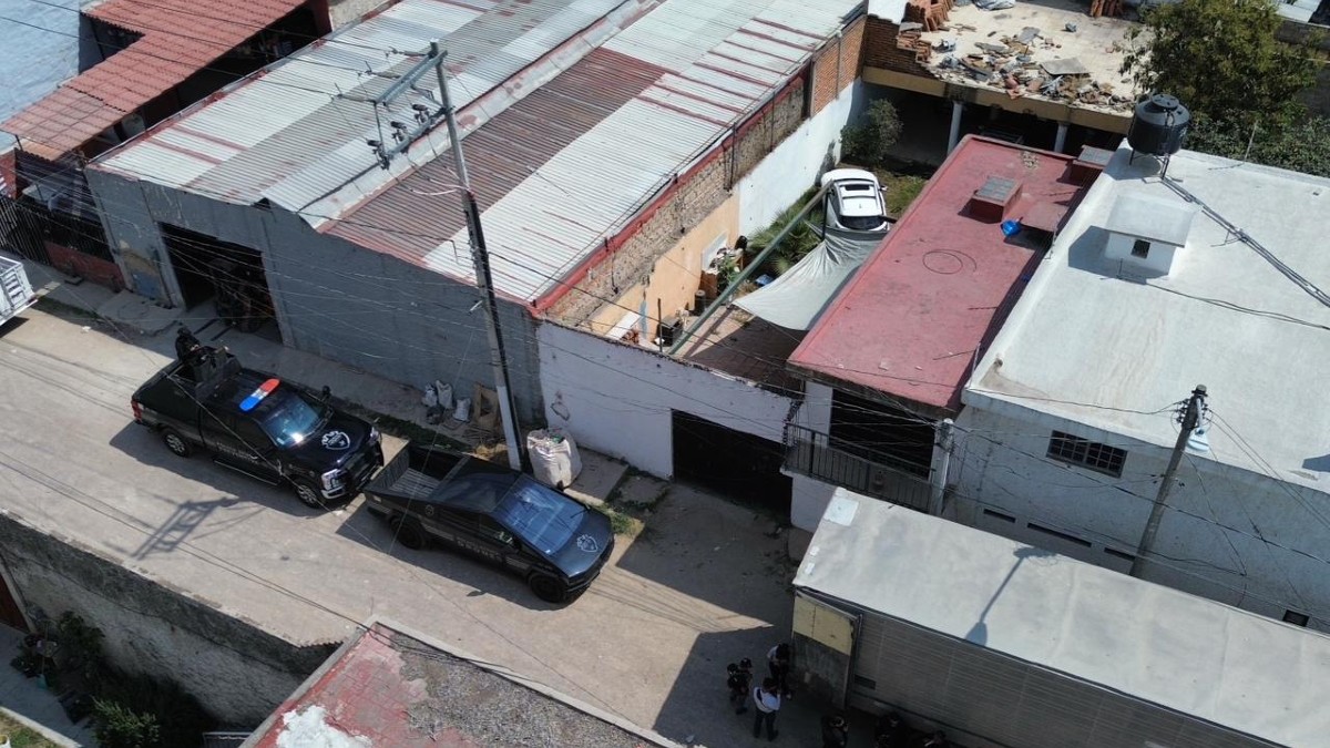 Vista aérea del interior de un predio en Zapopan con autos robados dentro y patrullas de Jalisco estacionadas al exterior