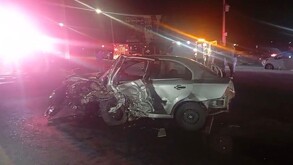 Se observa un carro destruido color gris, es de noche.