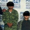 Dos hombres detenidos por personas vestidas de militar.