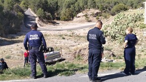 Se observa unos policías de espaldas, una camioneta al fondo en un barranco.