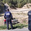Se observa unos policías de espaldas, una camioneta al fondo en un barranco.