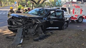 Camioneta Mitsubishi color negra con la parte frontal destrozada. Camión y elementos de Protección Civil y Bomberos de Guadalajara en el sitio