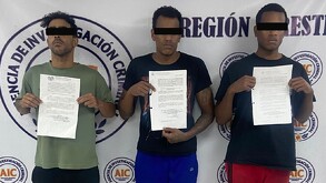 Se observa a tres hombres con cintilla negra en ojos, de tez morena, están parados.