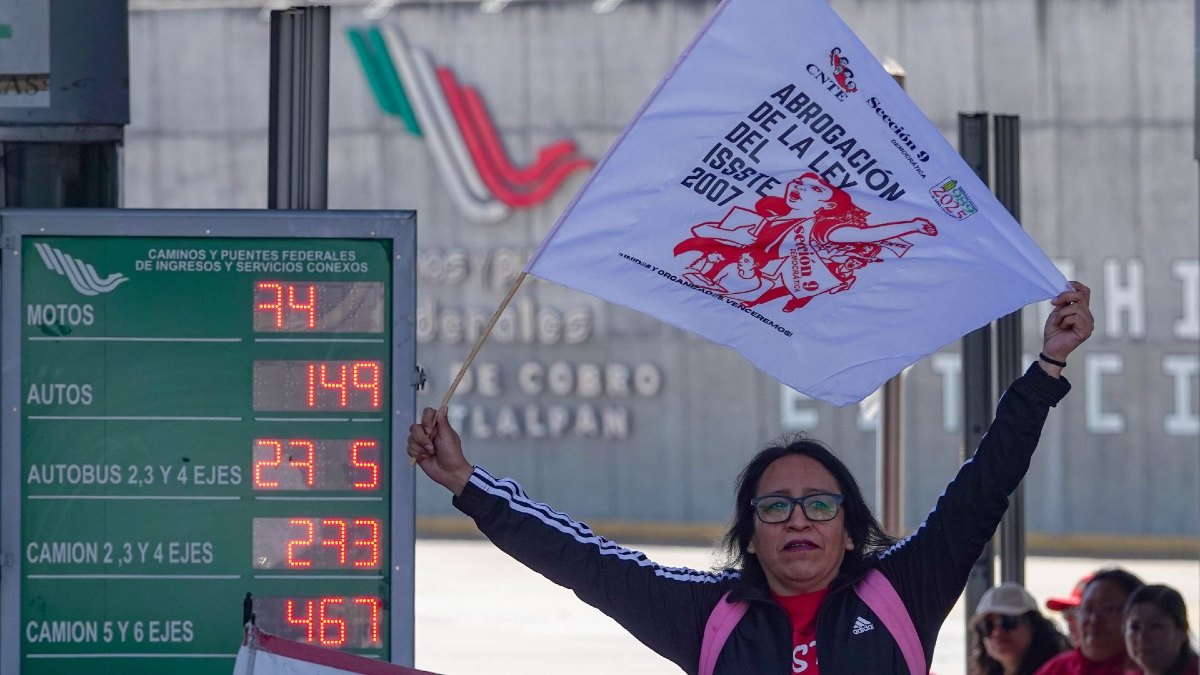 Mujer con una pancarta protesta en una caseta de Oaxaca.