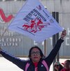 Mujer con una pancarta protesta en una caseta de Oaxaca.