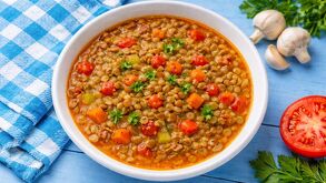 Un plato de lentejas tradicionales mexicanas adornado con champiñones, hierbas y jitomate.