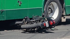Motociclista color negra tumbada sobre el asfalto con la parte frontal debajo de un camión color verde de la ruta 639 en Guadalajara