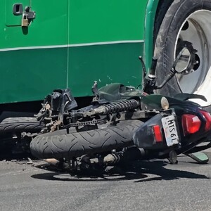 Motociclista color negra tumbada sobre el asfalto con la parte frontal debajo de un camión color verde de la ruta 639 en Guadalajara