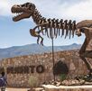 T-rex en la entrada del Museo del Desierto con un grupo de personas pasando a su lado.