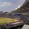 Una vista panorámica del Estadio Panamericano lleno de aficionados durante un juego nocturno de los Charros de Jalisco bajo un cielo crepuscular.