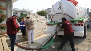 personas del gobierno entregan agua en pipas en colonias de la ciudad de puebla