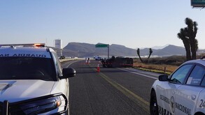 Se observa una cinta de precaución, unos carros sobre la carretera.