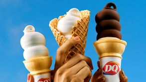 Varias personas sostienen conos de helado suave de Dairy Queen, mostrando el clásico diseño en espiral característico de la marca.