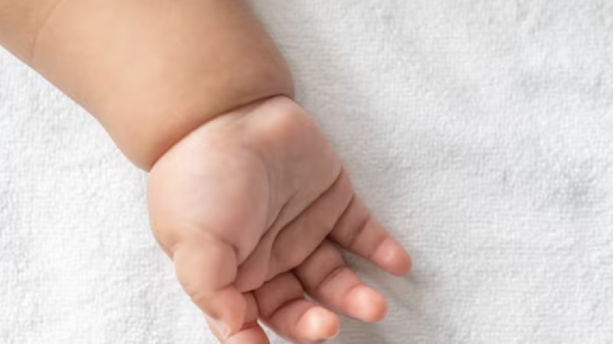 Mano de recién nacido en una toalla en color blanco