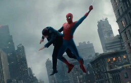 Spider-Man se balancea entre rascacielos de una ciudad mientras sujeta a una persona con un brazo para rescatarla, bajo un cielo nublado.